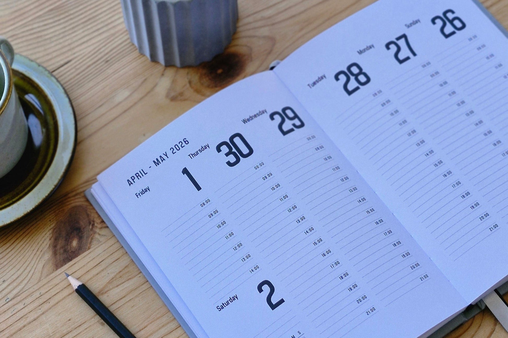 Calendar on a wooden surface with a light bulb and plant